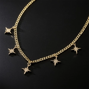 Gold plated choker necklace with five geometric zircon star pendants on a black background