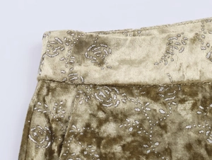 Close-up of olive velvet waist with metallic silver rose pattern and fine stitching