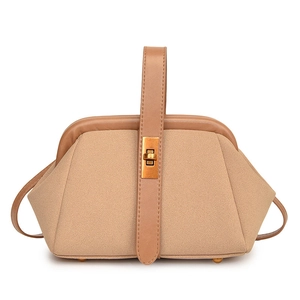 Detail of khaki suede trapezoid handbag featuring gold twist lock and smooth leather strap