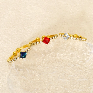 Detailed view of three gold vintage rings with red blue and white zircon on ice blocks