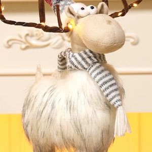 Detail of plush Christmas elk figurine with warm LED fairy lights and striped scarf