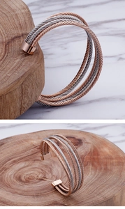 Macro view of multi-layer spiral metallic wire cuff bracelet in rose gold and silver