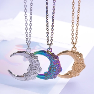 Detailed view of crescent moon pendants with floral embossing in silver, gold and rainbow