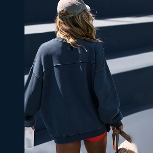 Detailed back view of oversized navy blue sweatshirt featuring black square patch on fabric