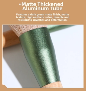 Detail of matte dark green thickened aluminum ferrule and wooden handle makeup brush