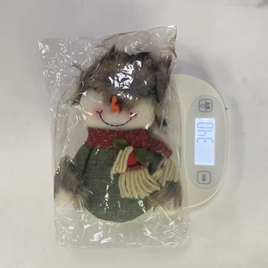 Detail shot of a handmade snowman Christmas ornament on a scale weighing 34.0 grams