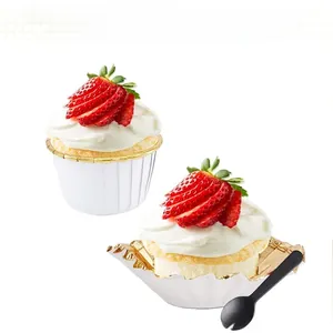Detail of gold foil rimmed cupcake liners with cream cake and small plastic fork