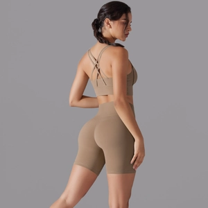 Dettaglio del reggiseno sportivo incrociato e pantaloncini a vita alta marrone yoga