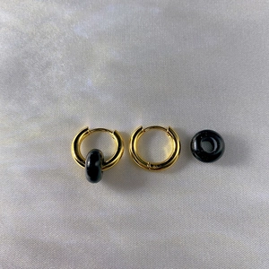 Detailed view of 18k gold plated stainless steel hoops with black natural stone charms