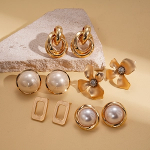 Detailed close-up of 5-pair earring set featuring faux pearls and golden floral shapes