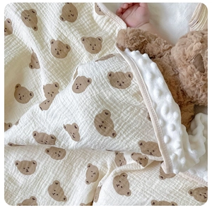 Detail of baby blanket with brown bear gauze side and soft white minky dot texture