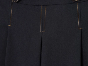 Détail de couture orange contrastée sur le tissu bleu foncé du short long décontracté
