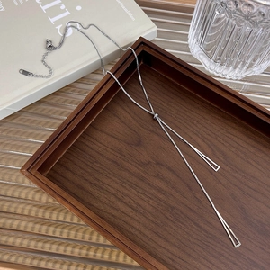 Silver titanium steel Y-shaped long sweater necklace with geometric bar pendant on wood