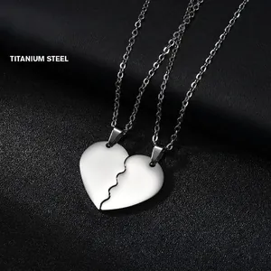Macro shot of two silver titanium puzzle heart pendants for couples on black leather