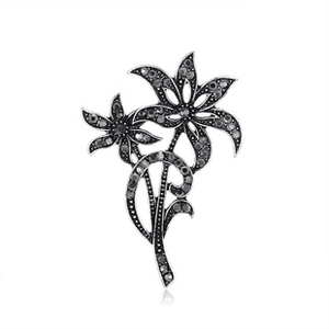 Detailed view of dual-flower baroque brooch with black zircons on silver alloy