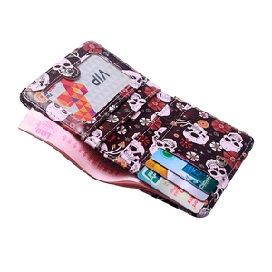 Short bi-fold wallet with pink skull and floral print, showing internal card slots and window