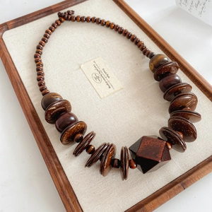 Macro detail of wood and coconut shell beads on a minimalist retro necklace