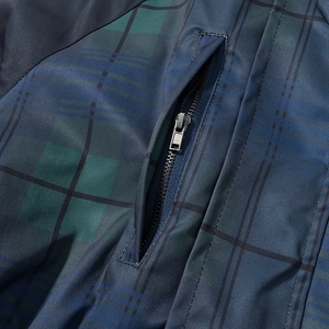 Detail of plaid coat showing dark blue check pattern and metal zipper pocket