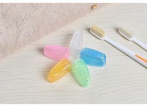 Set of five colorful translucent plastic toothbrush head covers on a wooden surface