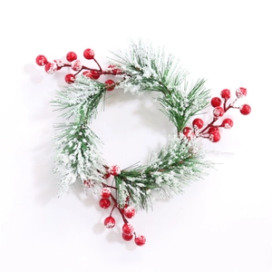 Detail of white snow-tipped pine needles and red berries on a Christmas wreath