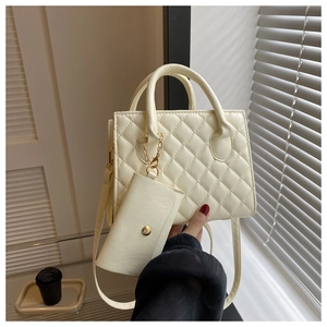 Detail of beige quilted PU leather handbag with matching small pouch and round handle