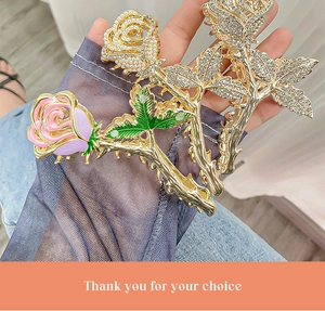 Detailed view of large gold rose hair claws with rhinestones and colorful enamel flowers