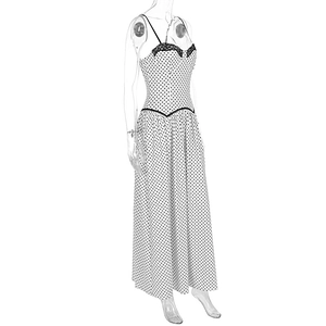 Detail of white polka dot dress featuring delicate black lace trim and V-shaped waist design