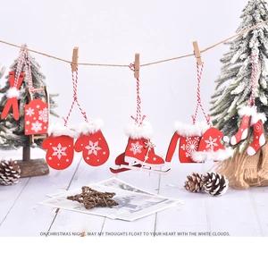 Three red wooden Christmas ornaments hanging by clips featuring gloves, skates, and a sweater
