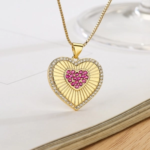 Elegant gold heart pendant necklace with red and white zircon stones in close-up view