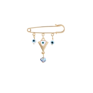 Detail of gold evil eye safety pin brooch with blue crystal charms on white background