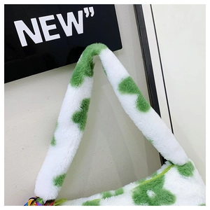 Detail shot of plush faux fur shoulder bag stitching and green floral texture on white