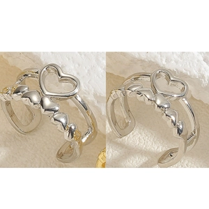 Detail view of silver heart-shaped open ring featuring a hollow center and side patterns