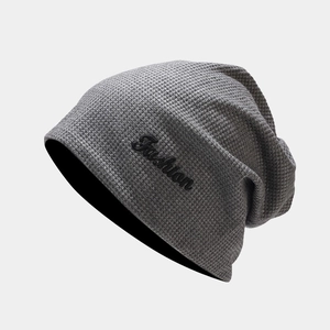 Détail du bonnet en maille gaufrée gris foncé avec broderie Fashion et texture douce