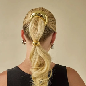 Polished 18k gold crescent hair clip and round band set shown on a model's hair