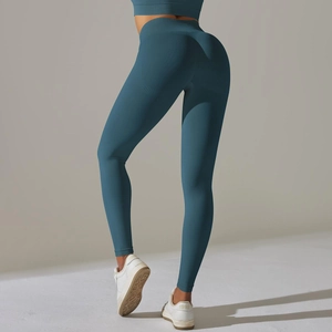 Detail view of high-waisted seamless knit yoga leggings in deep teal with ribbed waistband