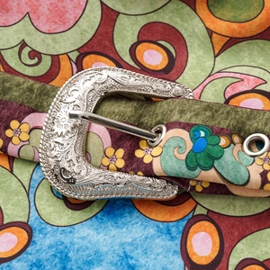 Close-up of bohemian printed swimsuit waist wrap with vintage engraved silver buckle