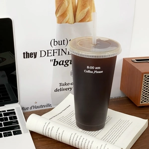 Lifestyle-Foto eines großen Mehrweg-Kaffeebechers mit Strohhalm auf einem Schreibtisch