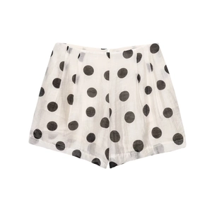 Close-up of white high-waist shorts with black polka dots showing detailed fabric texture
