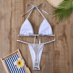 Détail à plat d'un bikini argenté brillant avec des anneaux dorés décoratifs