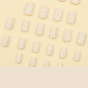 Cream white 3D short square fake nails with knitted texture pattern flat lay on beige base