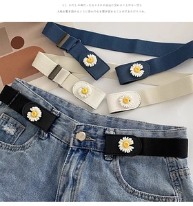 Close-up of elastic waist belts featuring daisy flower buckles and metal hardware detail