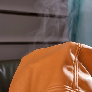 Detailed macro view of orange-brown faux leather cushion cover with steam for breathability