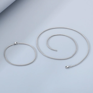 Polished silver stainless steel braided chain necklace and bracelet jewelry set flat lay