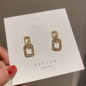 Detailed view of gold geometric rectangular earrings with sparkling crystal pavé accents