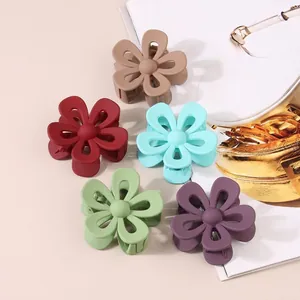 Set of 5 matte hollow flower hair claws in assorted Morandi colors on a beige background