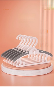 Detail of white telescopic baby hangers with grey non-slip pads and wide shoulder design