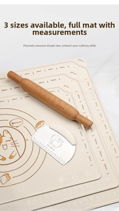 Close-up of silicone baking mat with measurement scales, wooden rolling pin and dough scraper