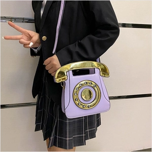 Detail of creative purple telephone-shaped crossbody bag worn by a model