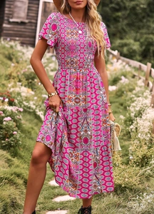 Vue détaillée d'une robe longue bohème rose à fleurs avec buste froncé et jupe à volants