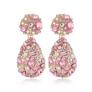 Macro view of teardrop earrings with pink crystals and rhinestones in rose gold base